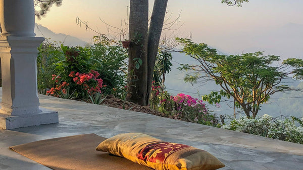 Yoga retreat group practicing at sunrise on a covered wooden deck